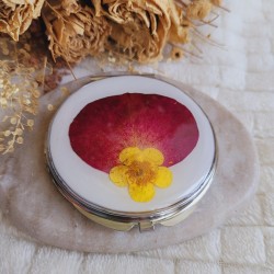 Miroir de poche rond agrémenté d'un pétale de Rose et d'une fleur séchée de Bouton de Rose.