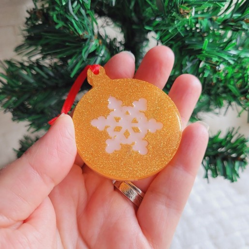 Boule de Noël en résine dorée nacrée et motif flocon.