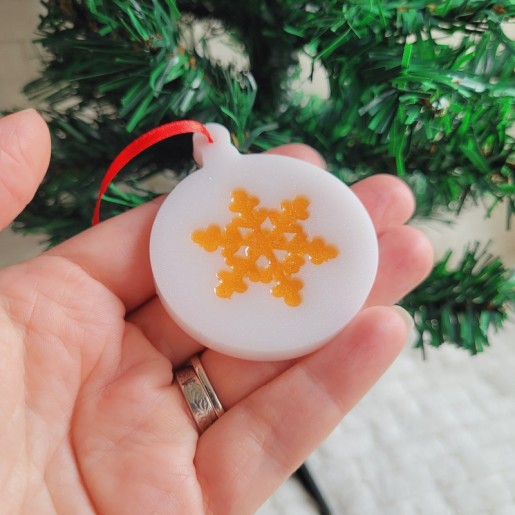 Boule de Noël en résine blanche nacrée et motif flocon.