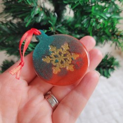 Boule de Noël en résine verte et rouge nacrée et motif flocon.