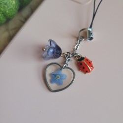 Bijoux de téléphone pendentif coeur avec fleur séchée de Myosotis.
