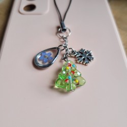 Bijoux de téléphone spécial Noël avec pendentif sapin de Noël en verre et fleurs séchées de Myosotis.