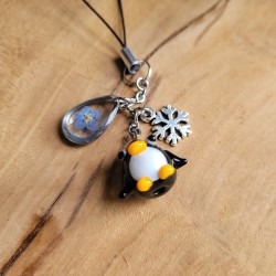 Bijoux de téléphone spécial Noël avec pendentif Pingouin en verre et fleurs séchées de Myosotis.