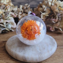 Boule de Noël en plastique avec fleur séchée d'Immortelle orange et fausse neige.