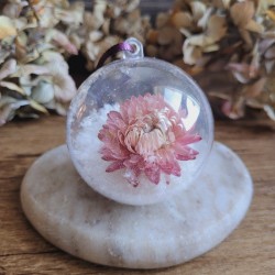 Boule de Noël en plastique avec fleur séchée d'Immortelle rose et fausse neige.