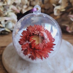 Boule de Noël en plastique avec fleur séchée d'Immortelle rouge et fausse neige.