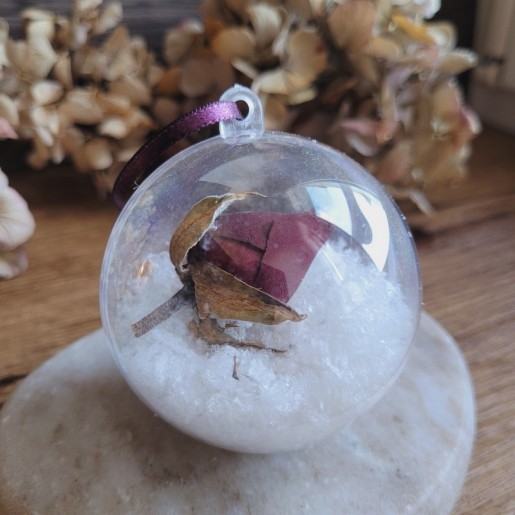 Boule de Noël en plastique avec fleur séchée de Bouton de Rose et fausse neige.