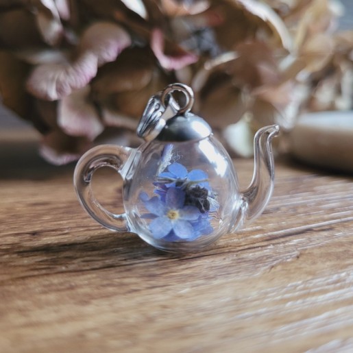 Pendentif théière en verre et fleurs séchées de Myosotis.