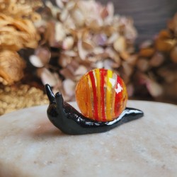 Saturne, figurine escargot en résine avec une bille issue de récupération.