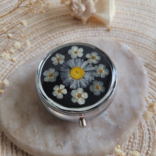 Pilulier rond en métal argenté, résine et fleur séchée de Pâquerette et Spirée. Pilulier 3 compartiments.