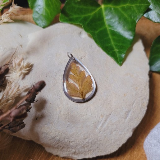 Pendentif rond fleurs et feuilles séchées naturelles en résine.